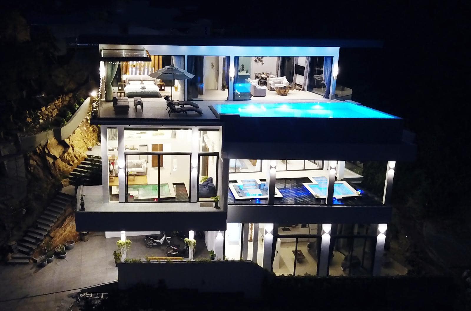 Magic Villa at night with all three floors and pools lit
