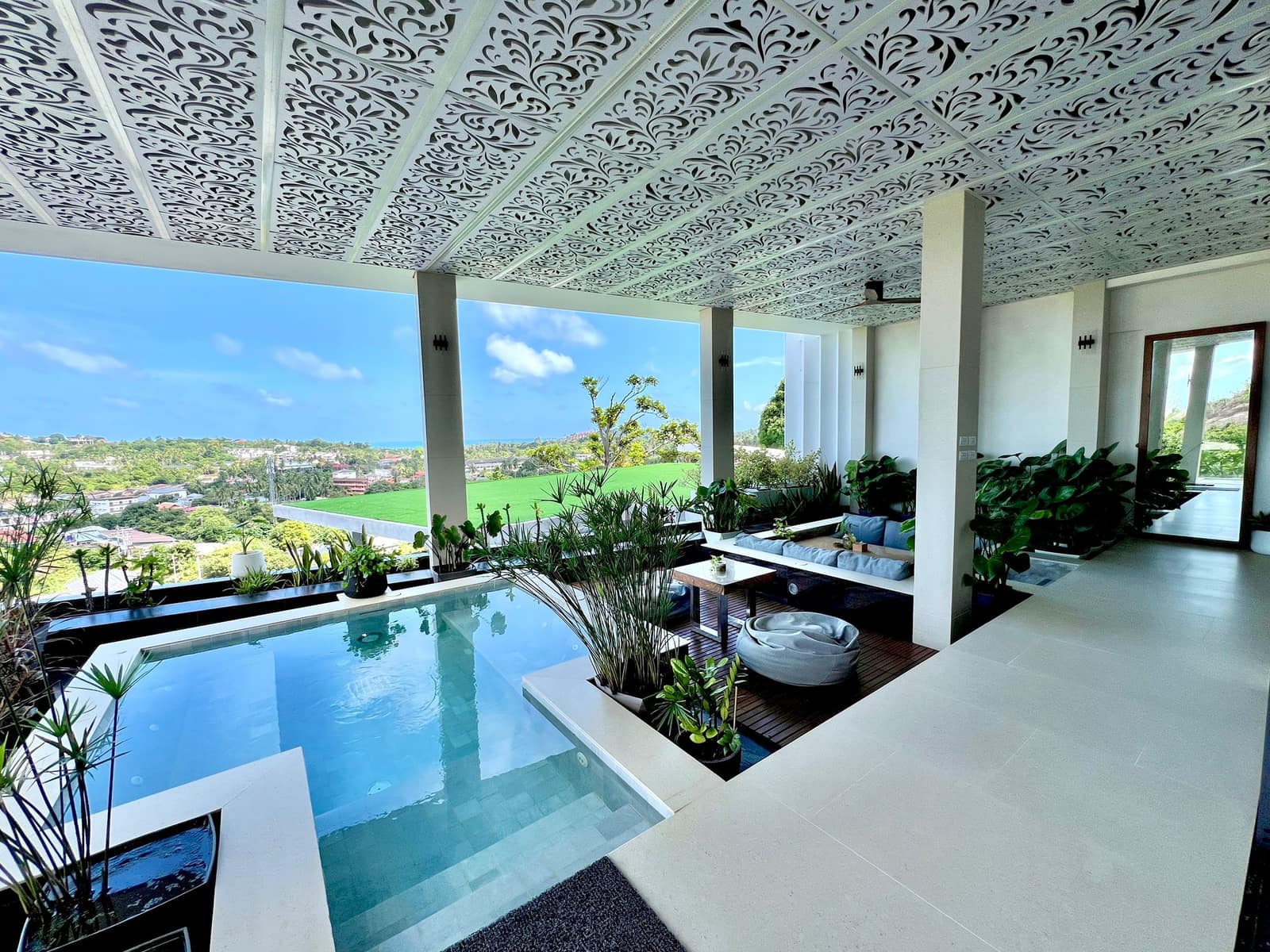 Covered pool lounge with carved ceiling and island views