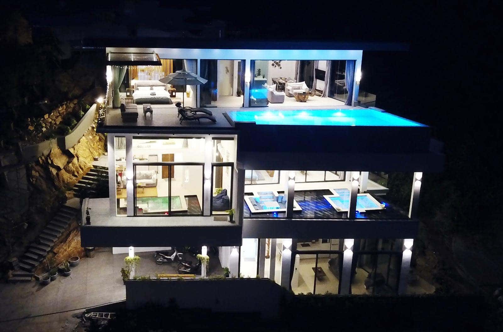 Magic Villa at night with all three floors and pools lit