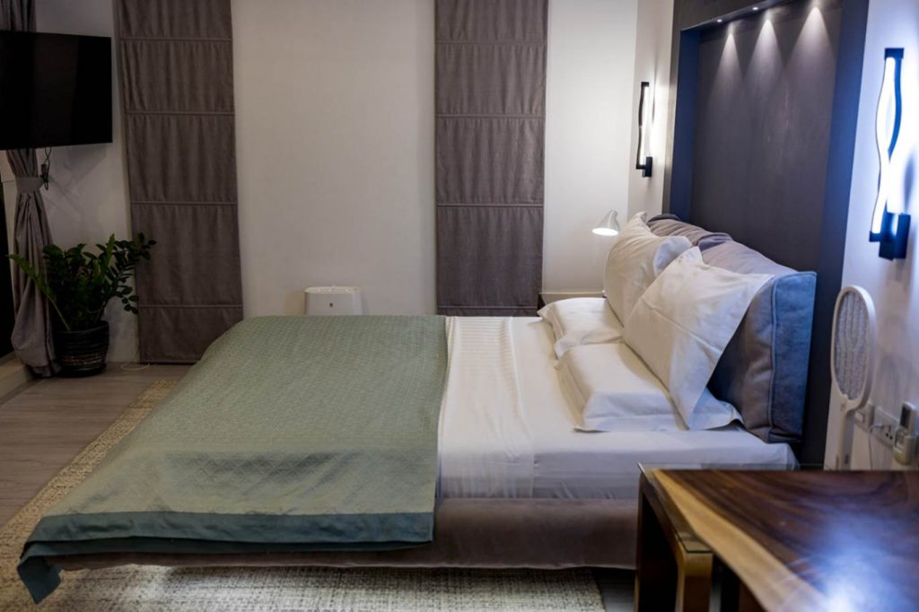 Cozy bedroom at Magic Suites featuring a stylish interior with modern amenities and plush bedding.