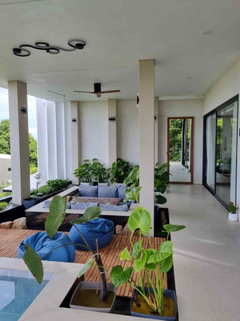 Spacious family-friendly Magic Suites villa lounge with plush seating and lush indoor greenery.