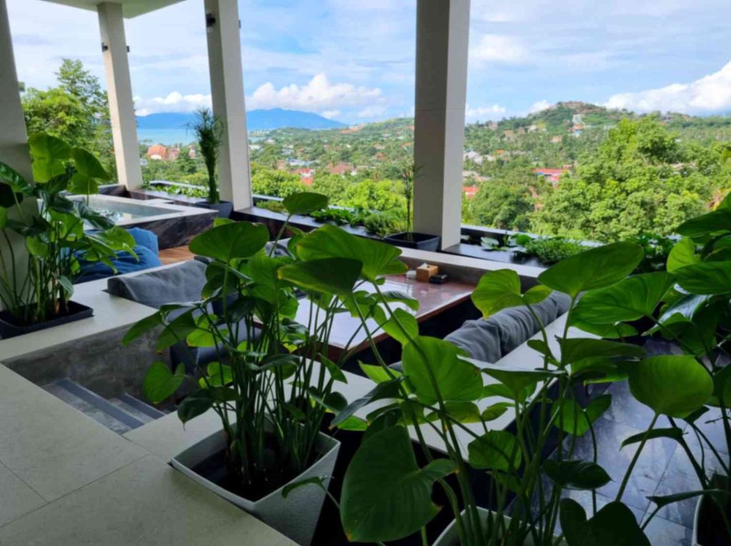 Terrace lounge in a family-friendly villa at Magic Suites with lush greenery and scenic mountain views.