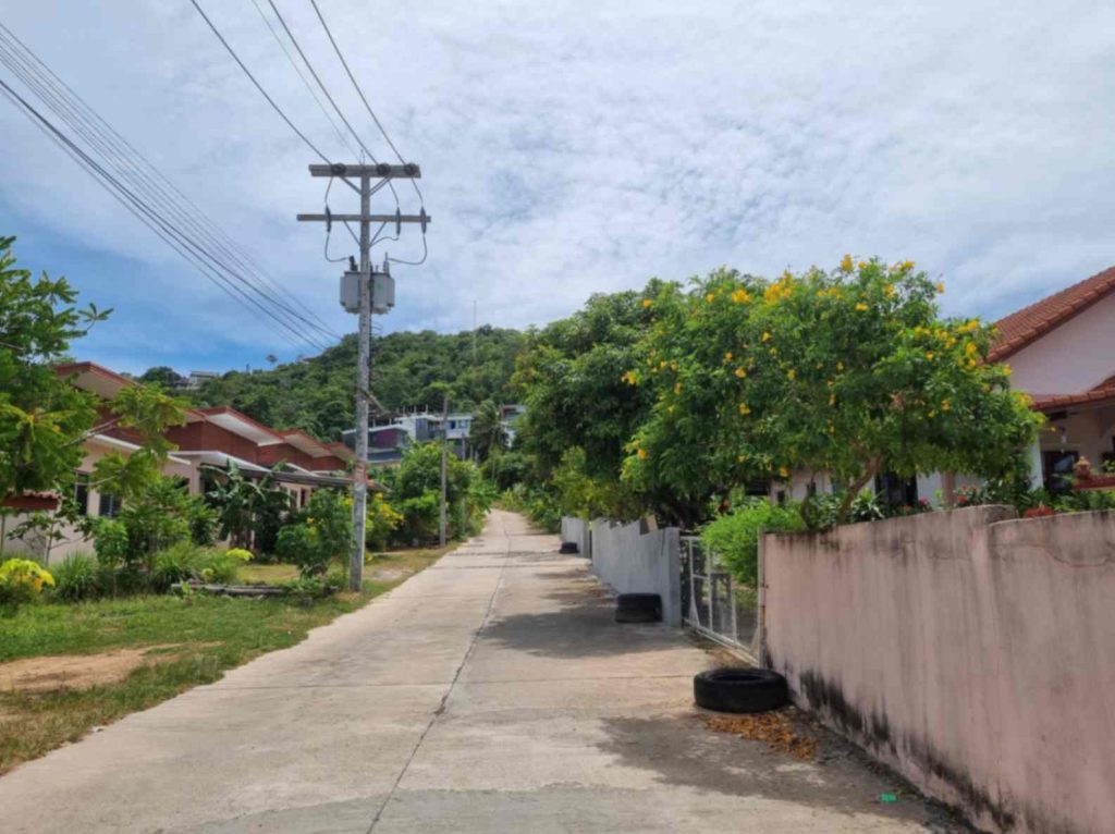 Quiet residential street in Koh Samui surrounded by lush tropical greenery, ideal for family-friendly stays.