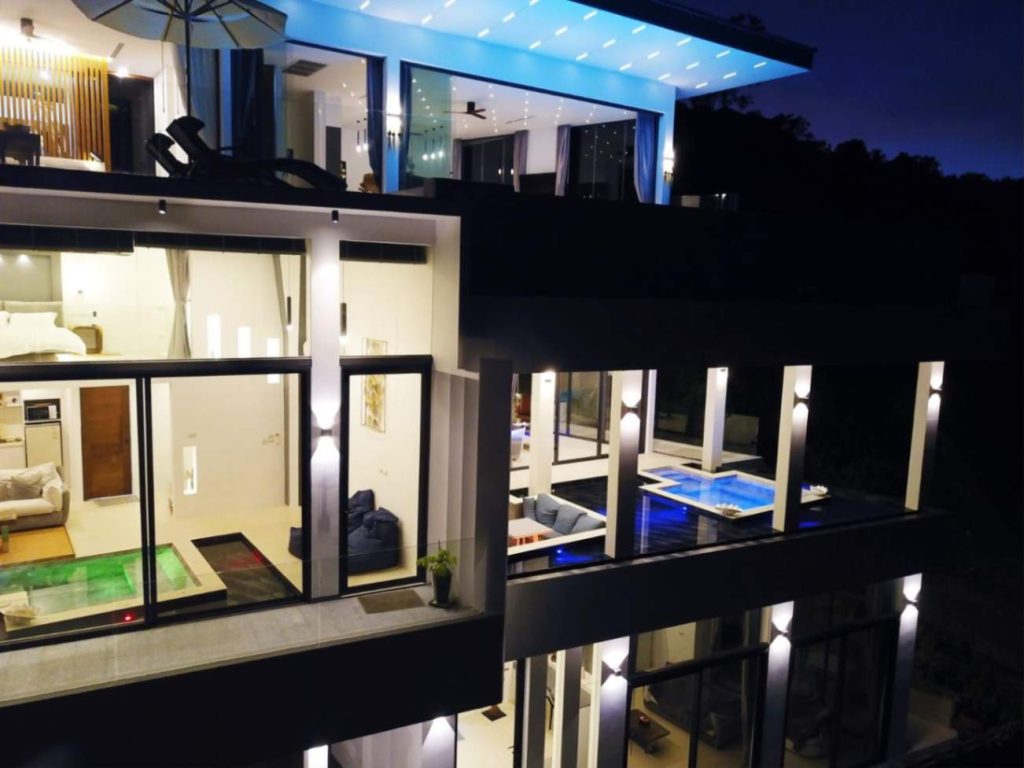 Night view of Magic Suites showcasing multi-level modern architecture with illuminated interiors.