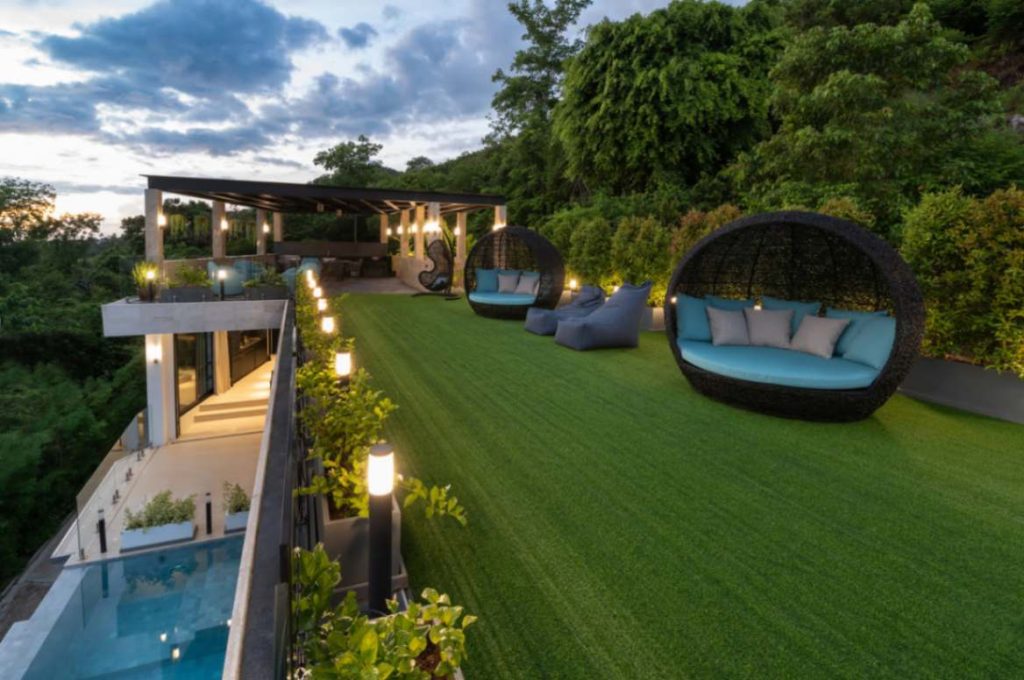 Lush green external lounging area of the Modern Tuxedo Villa in Magic Suites.