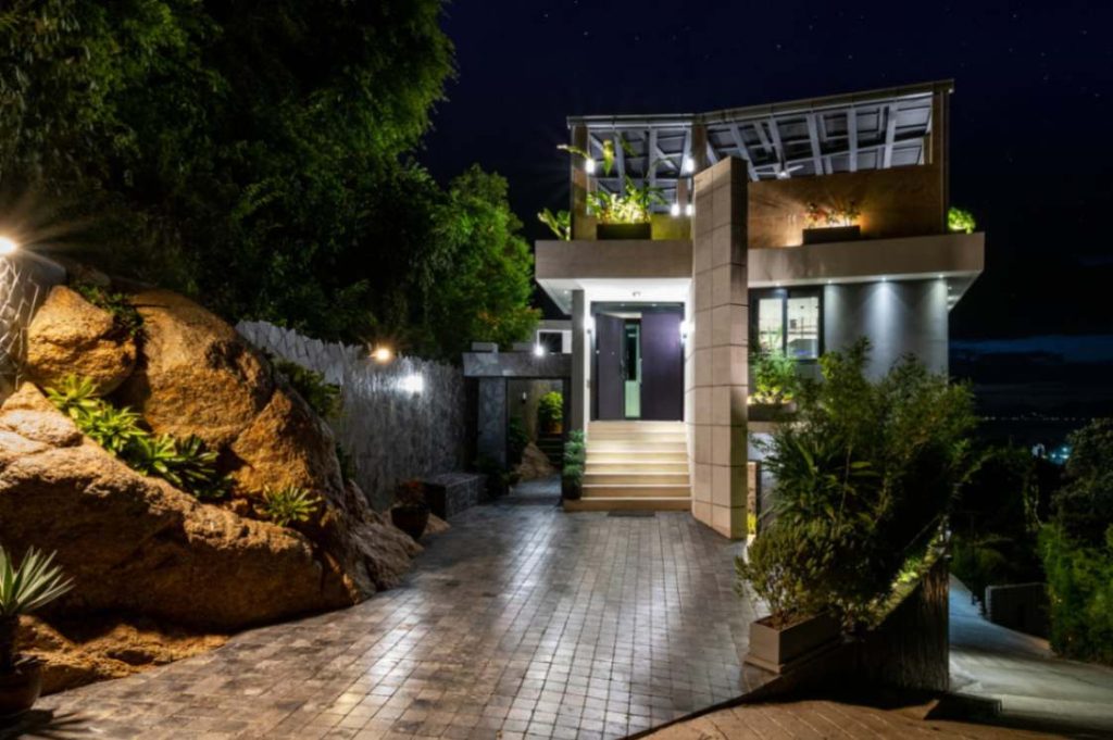 Nighttime view of the Magic Suites villa showcasing the lush greenery around it.