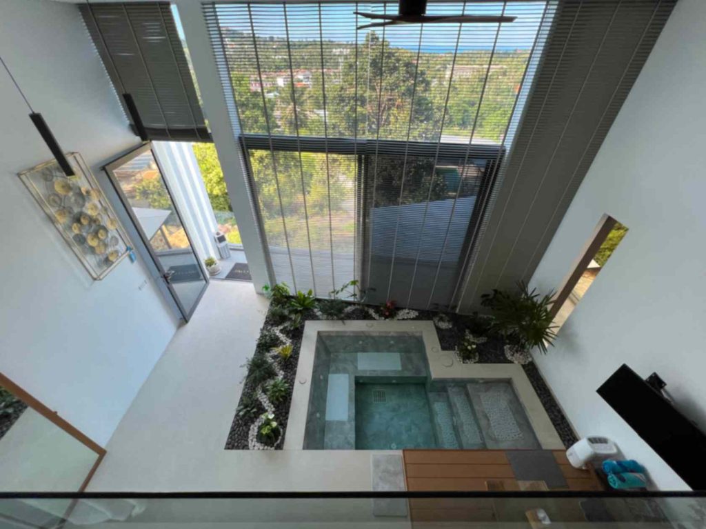 Elevated view of a luxurious Sunrise suite with private plunge pool surrounded by lush plants.
