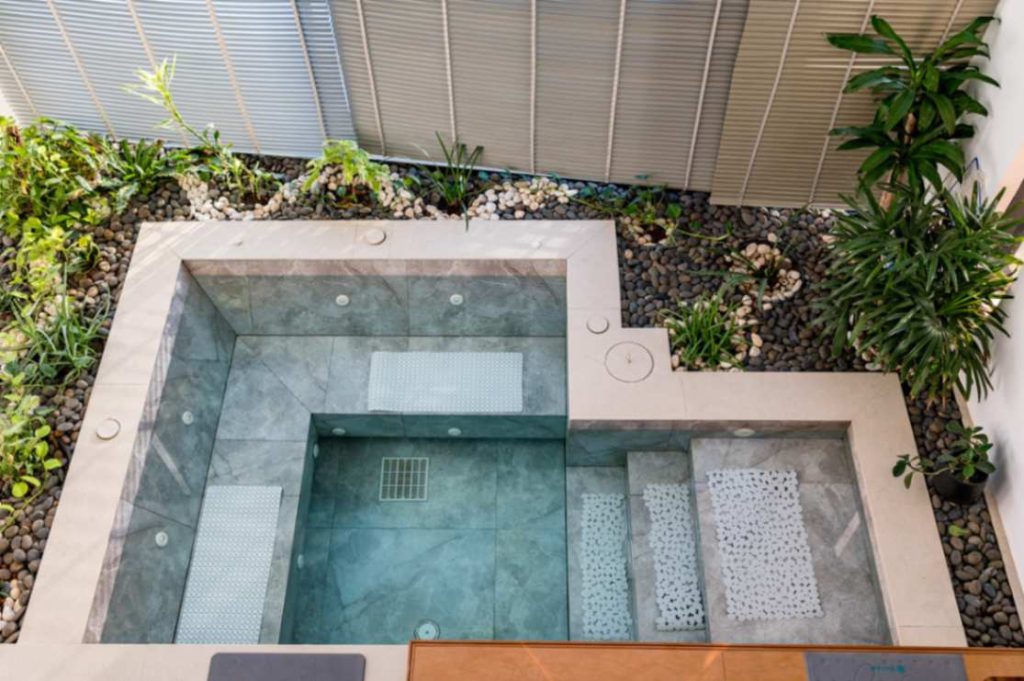 Small pool with steps, surrounded by greenery, in the Sunrise Suite.
