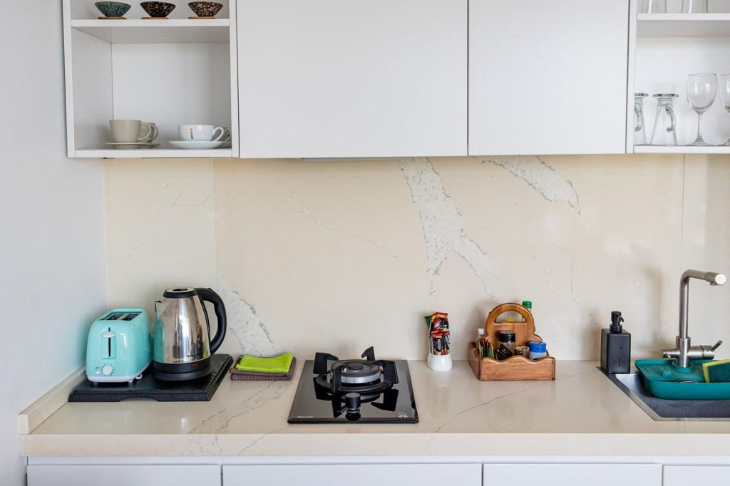 Modern kitchen countertop in Magic Suites with stylish appliances and marble backdrop.