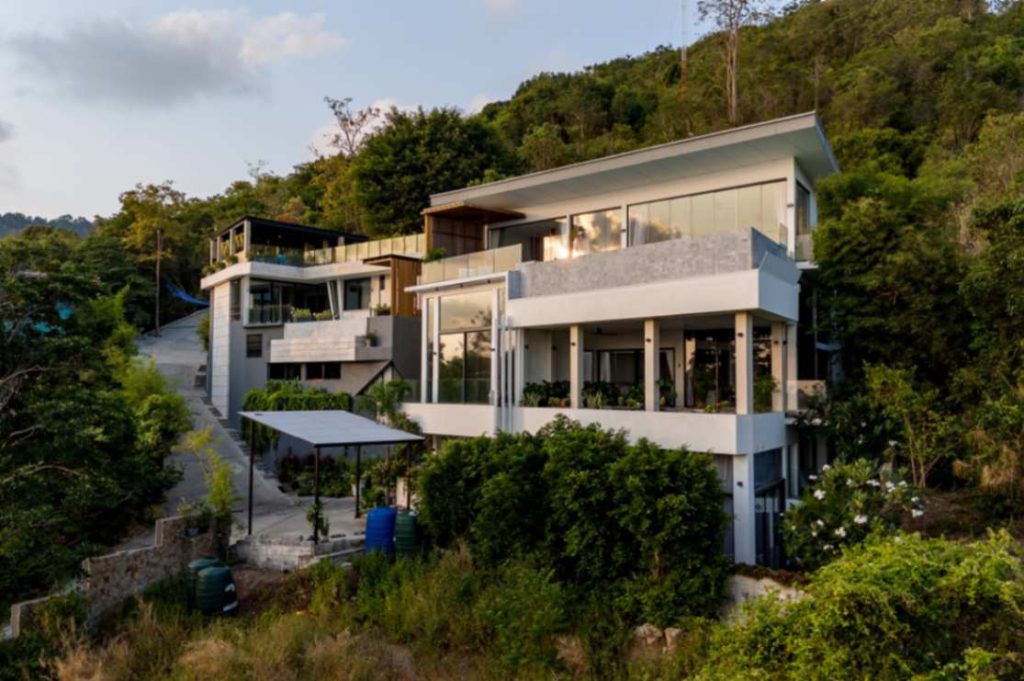 Aerial drone view of the majestic Magic Suites villa nestled in the green hills of Koh Samui.