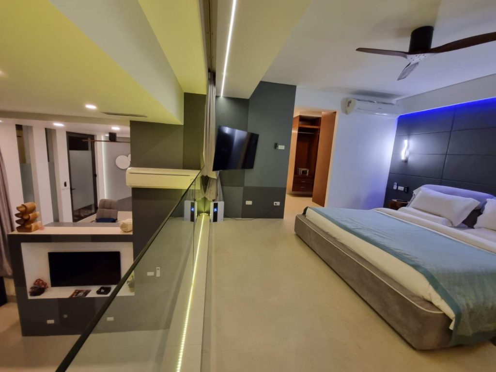 Modern Garden Suite featuring a bedroom area, reflective glass partition, and integrated living space.