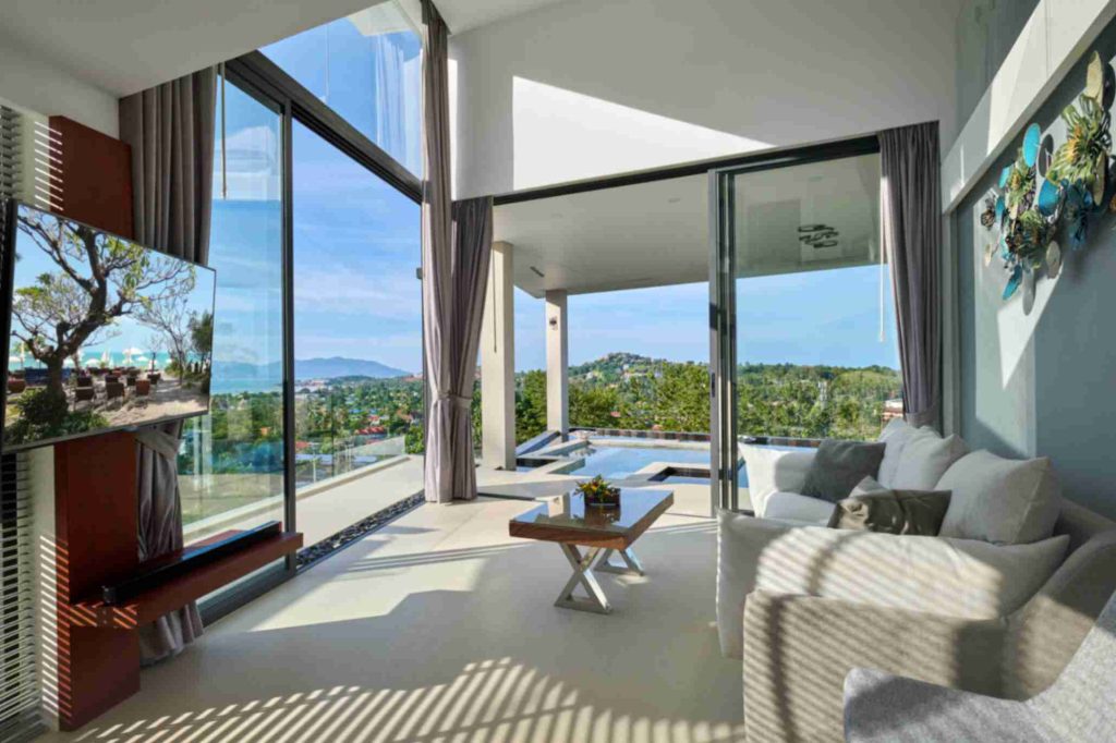Bright and airy room in Magic Suites with expansive glass walls offering panoramic mountain views.