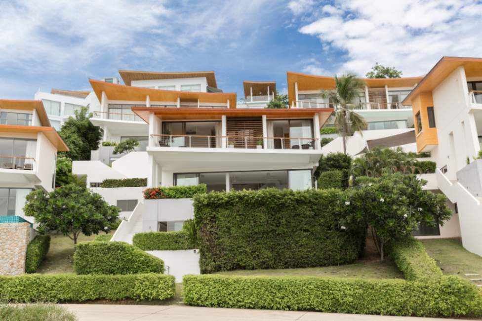 Modern tiered villas in Koh Samui with lush landscaping, showcasing upscale architecture.