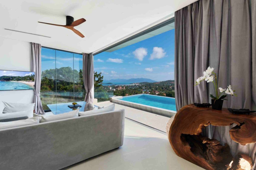 Luxury bedroom in Magic Suites with panoramic ocean views, infinity pool, and elegant decor.