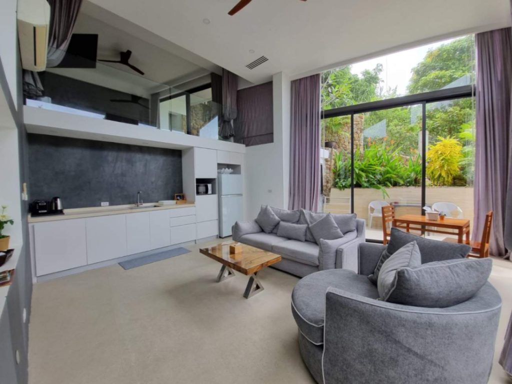Modern living space in the Garden Suite with a view of plants outside.